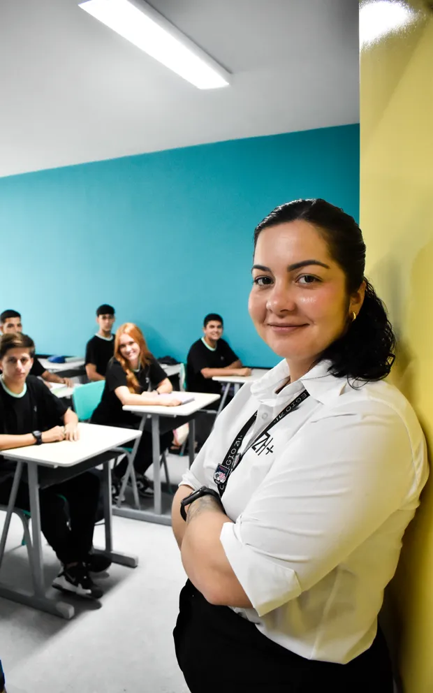 Professora do ZH+ em sala, com a turma do Ensino Médio ao fundo